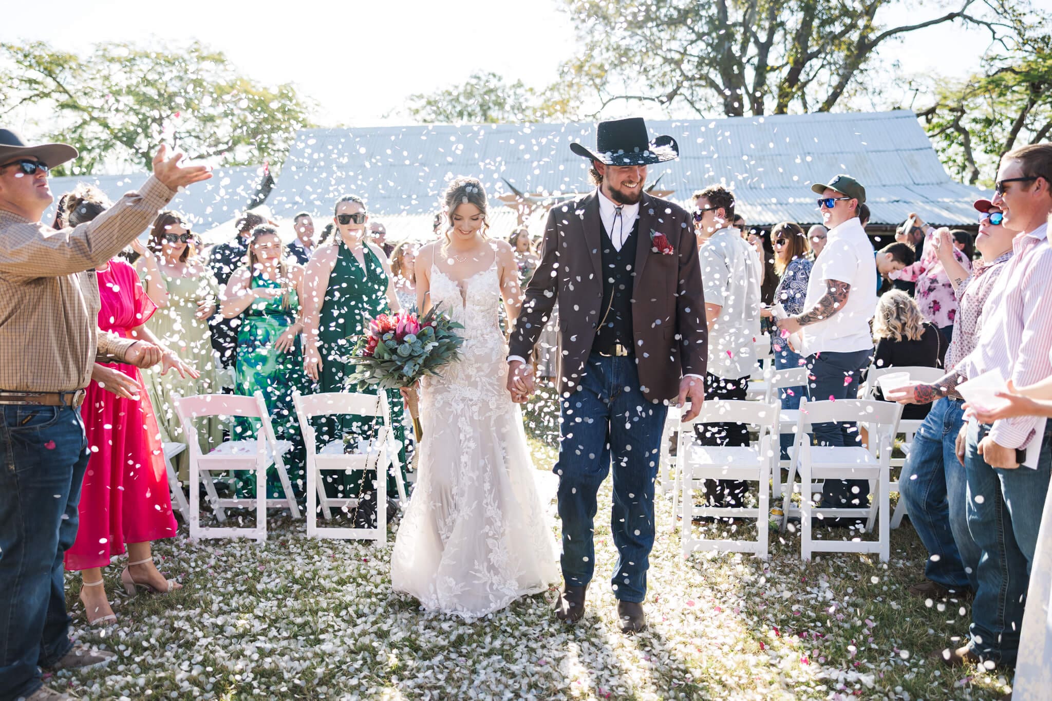 Bride and Groom recessional walk down the aisle while their friends and families throw confetti over them. Located at the Glenmore Homestead Rockhampton.