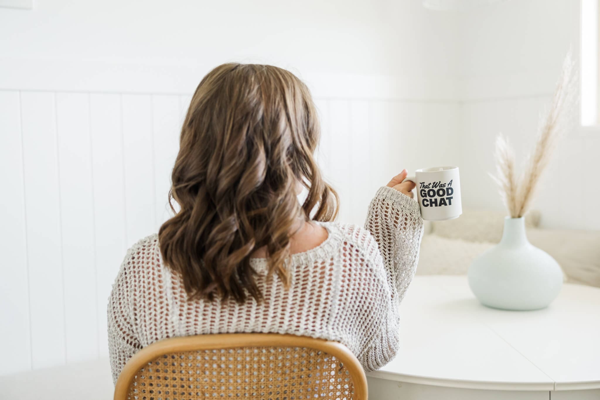Woman holding a cup for her personal branding photos to tell her business's story. The cup reads 'that was a good chat'.