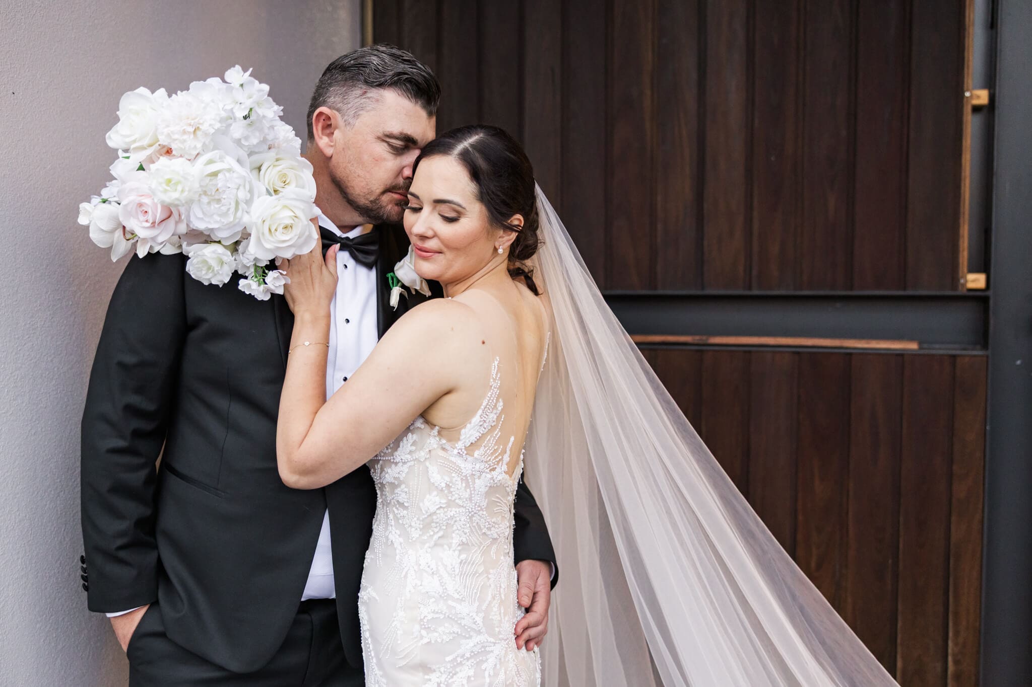 Bride and groom share a tender moment in front of Headricks Lane, a Rockhampton wedding venue
