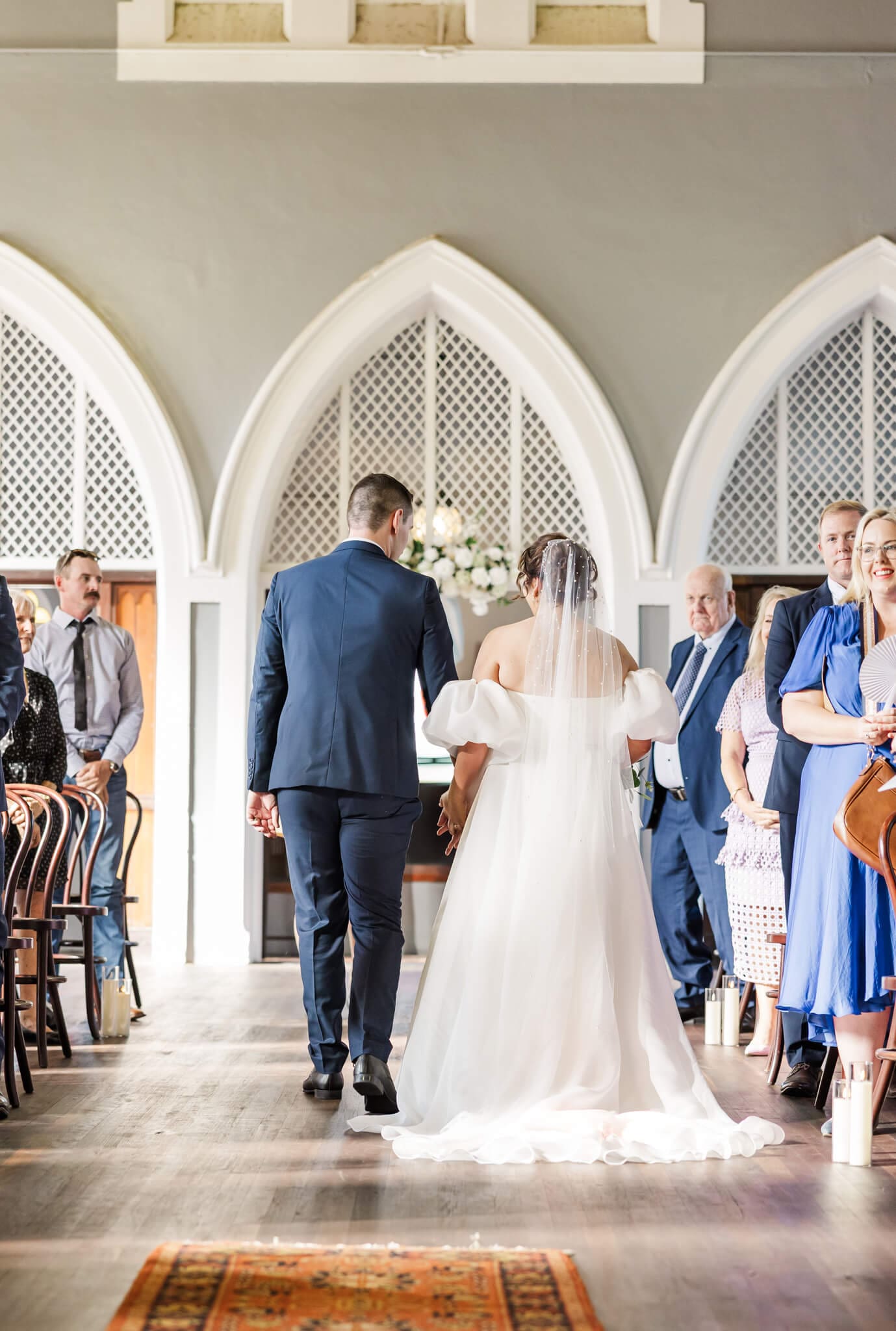 Recessional walk down the aisle for the bride and groom on their wedding day. Located at a Rockhampton wedding venue, in an old church.