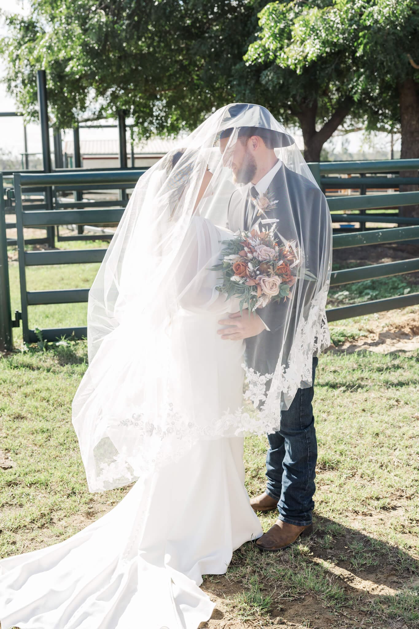Stunning bride and groom portrait at a Rockhampton wedding venue. with the bride and groom under the veil, kissing.