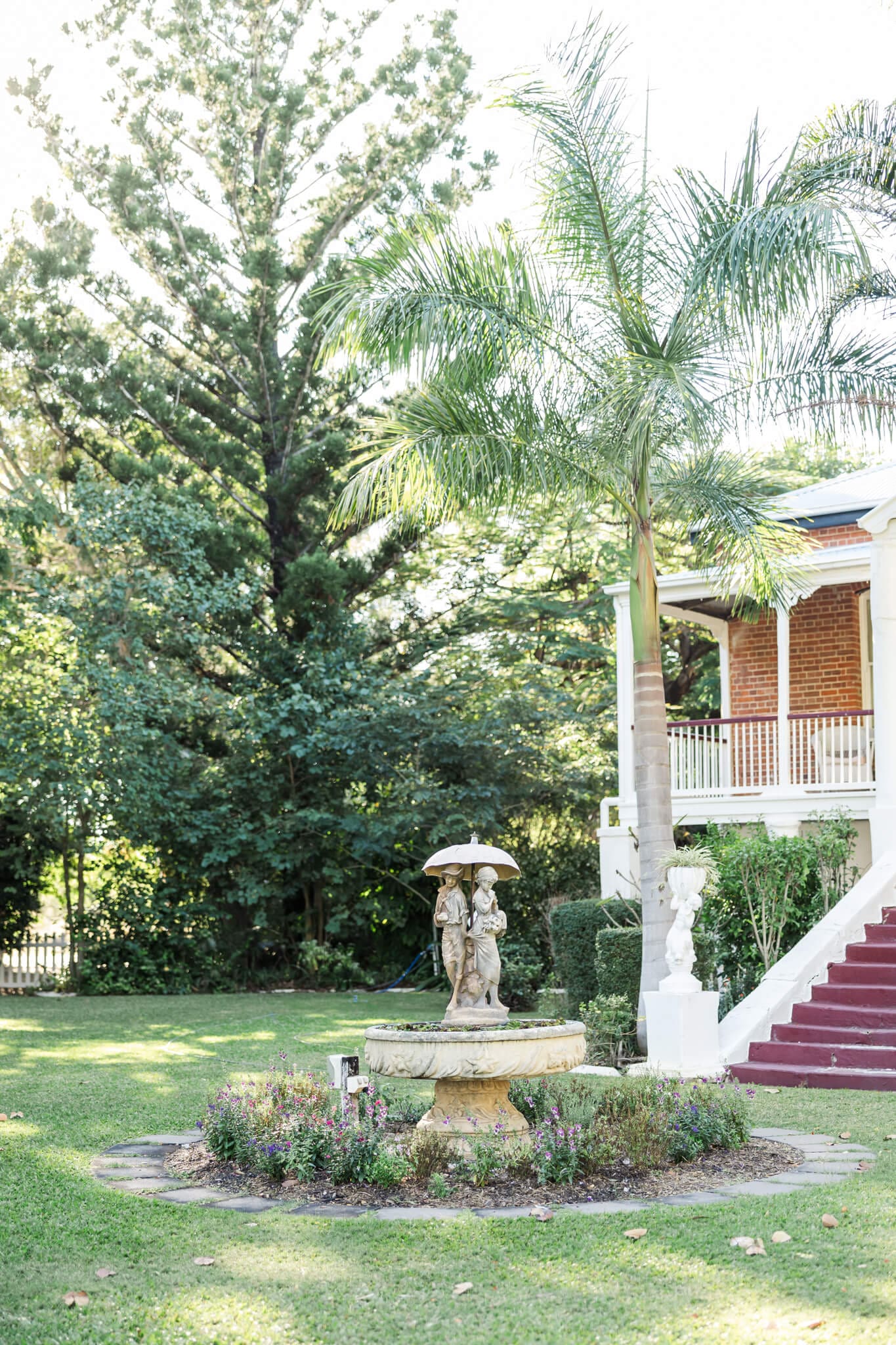 Beautiful gardens in one of the beautiful Rockhampton wedding venues. A bird bath with a statue of two people in the middle of a small circular garden.