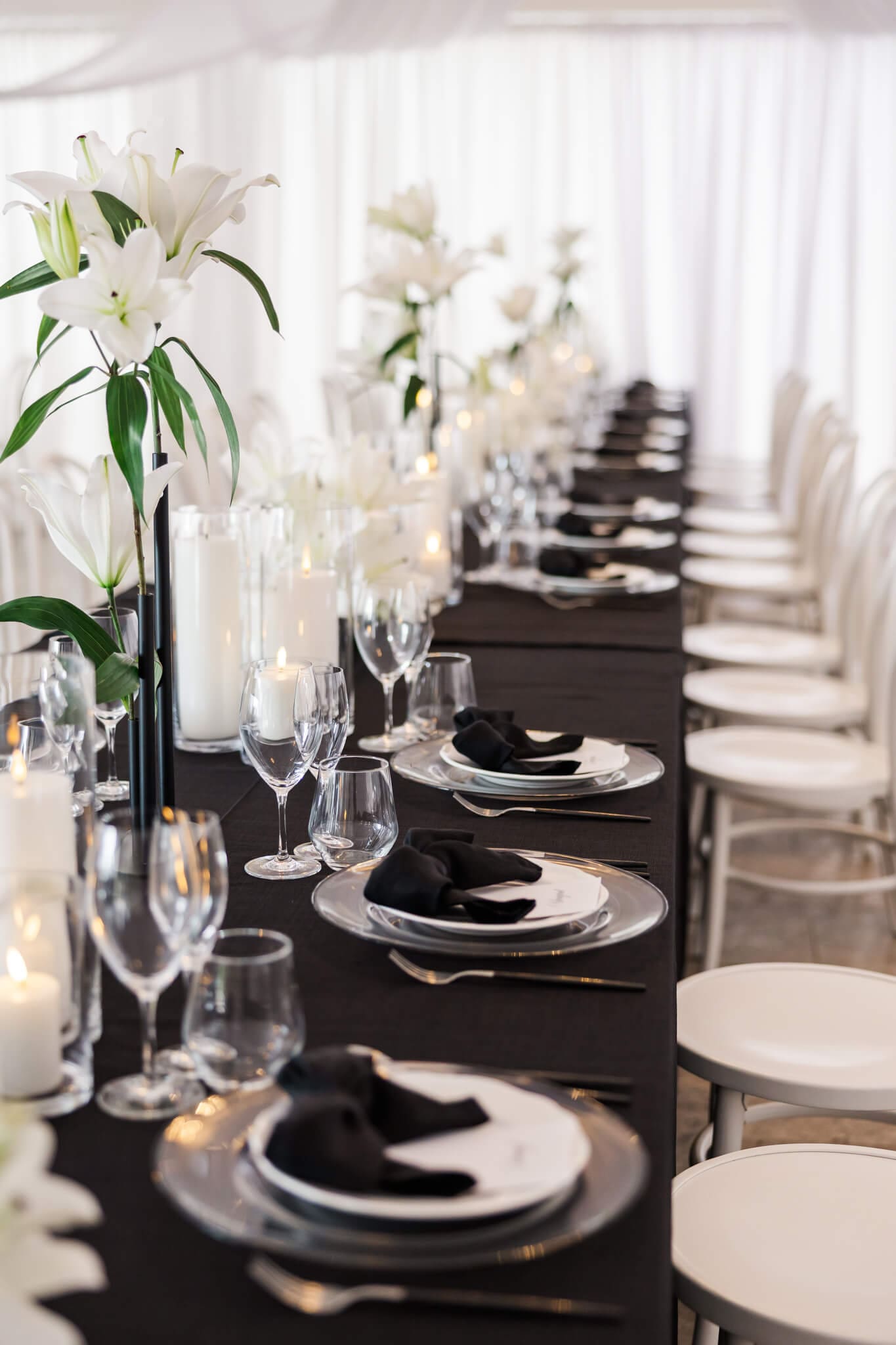 Detail shot of wedding table. Black tablecloth, beautiful orchids, black napkins in shapes of bows.
