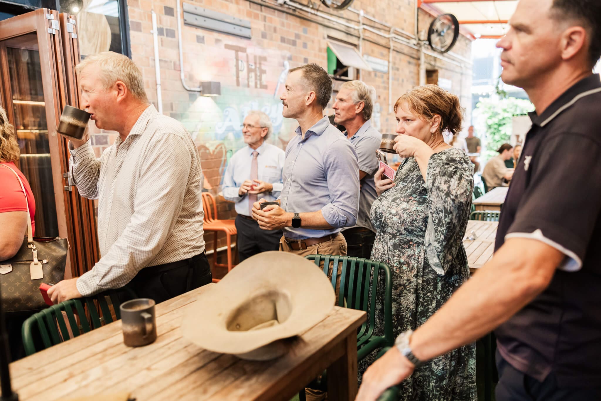 Business men and women drink coffee and network at an event at The Alley, Yeppoon.