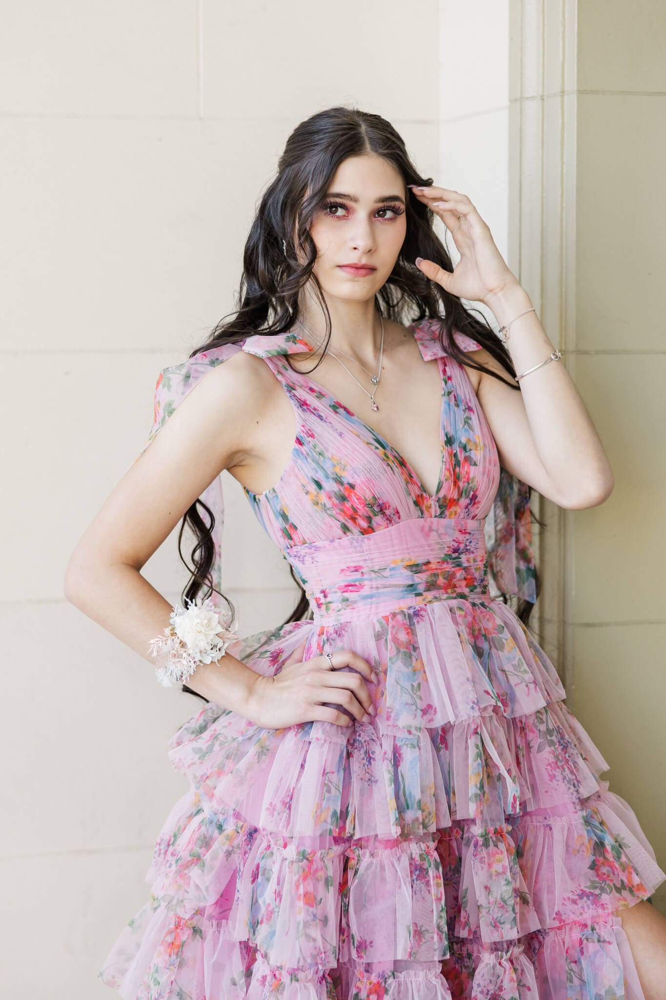 Young girl poses for her graduation portrait with a corsage on her wrist created by Lilly and Lotus