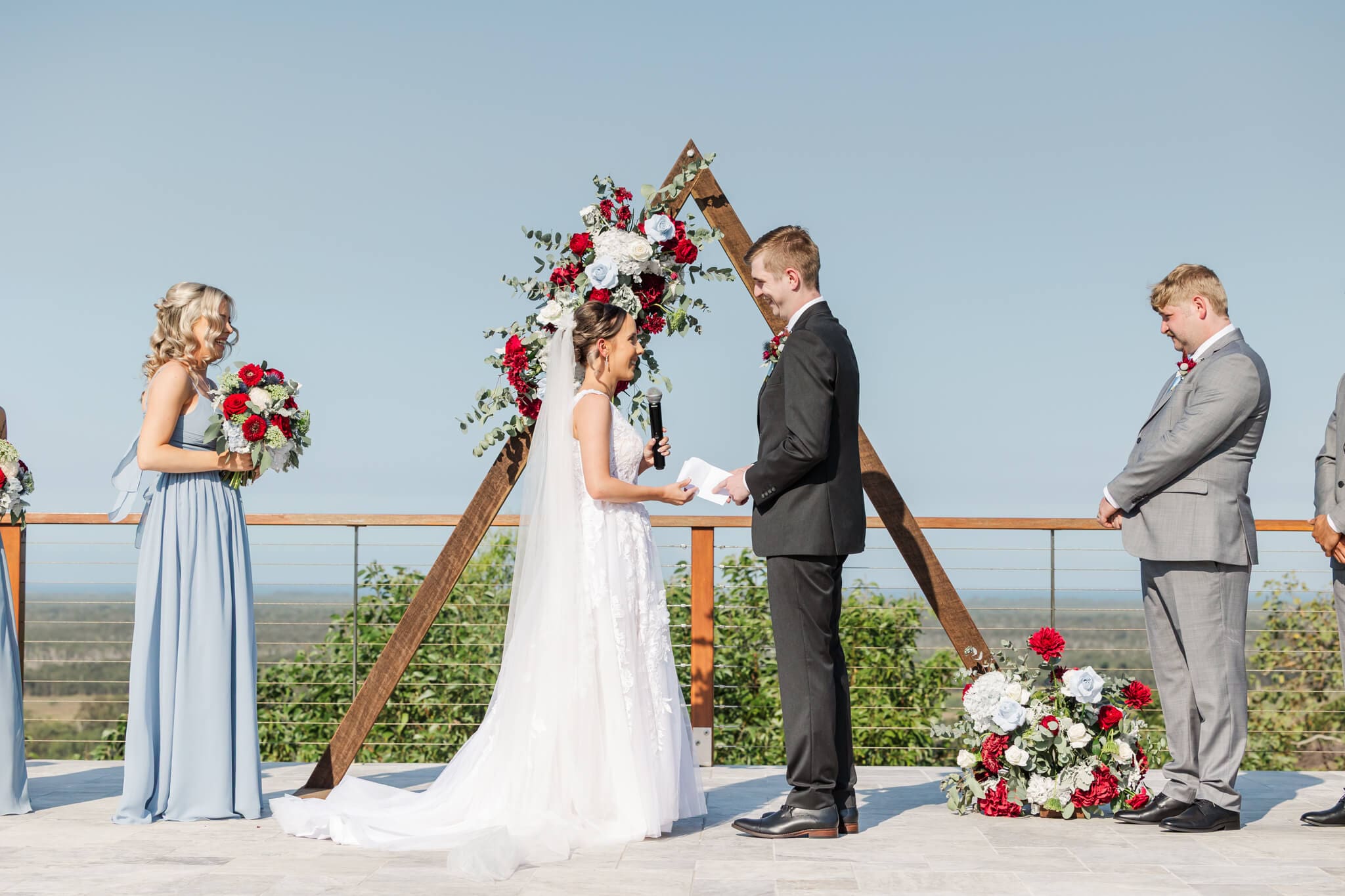 Bride and Groom exchange vows in front of a beautiful arbor over looking a gorgeous view towards the distant ocean.