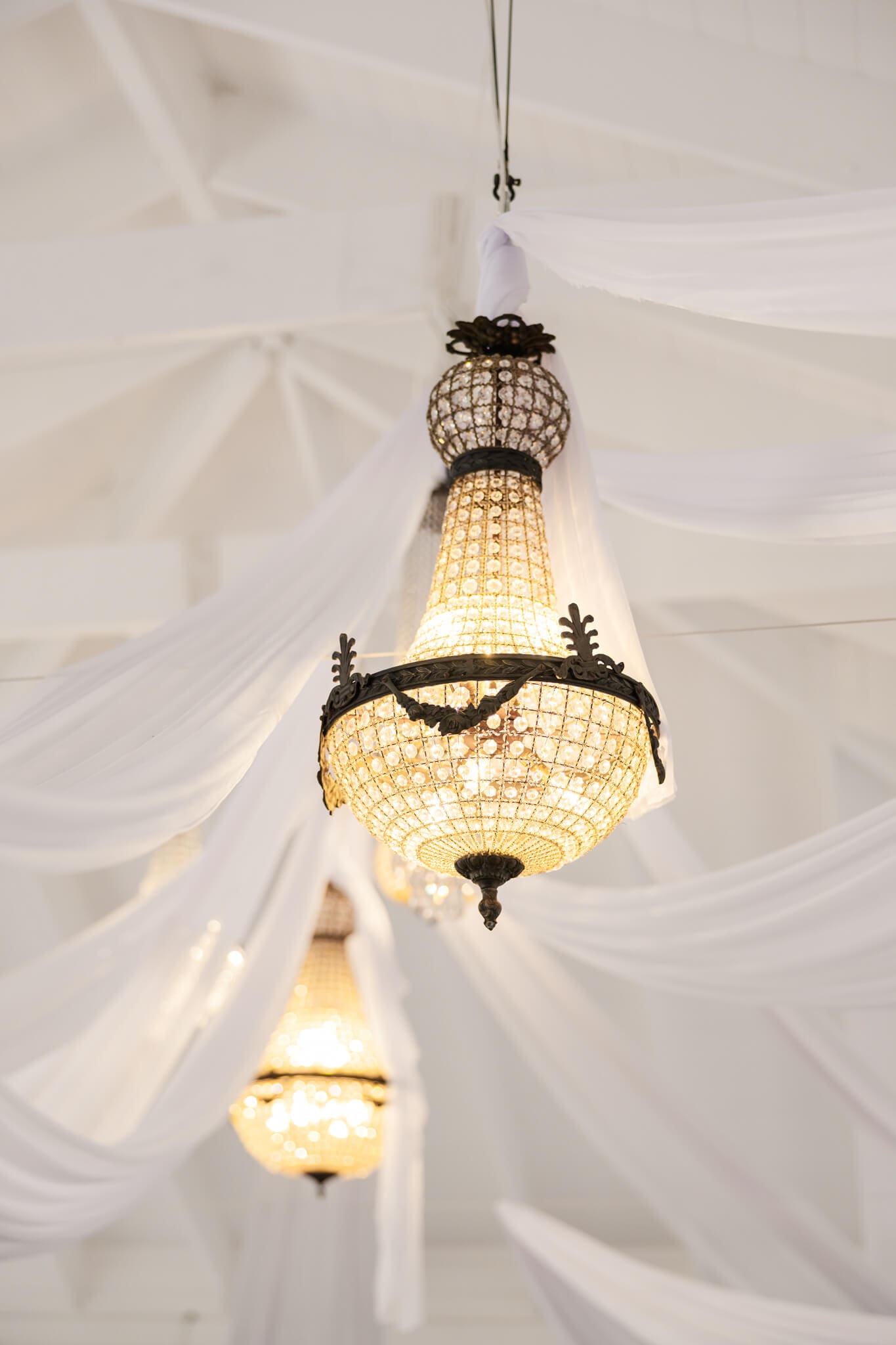 Stunning chandelier type lamps amongst luxury drapery, styled by Vintage Hire.