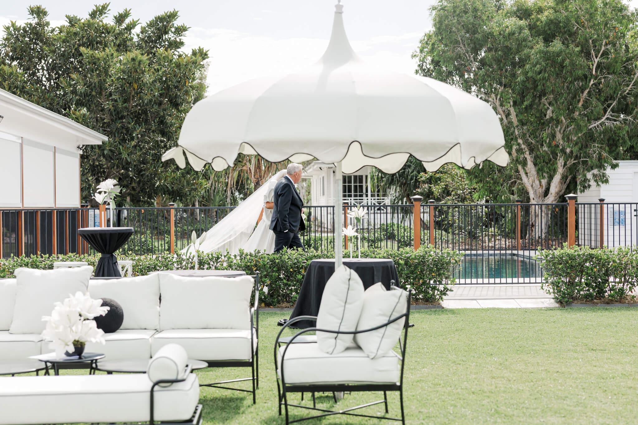 Bride is walked down the aisle with her father. Stunning luxury wedding venue near Yeppoon, styled by Vintage Hire.