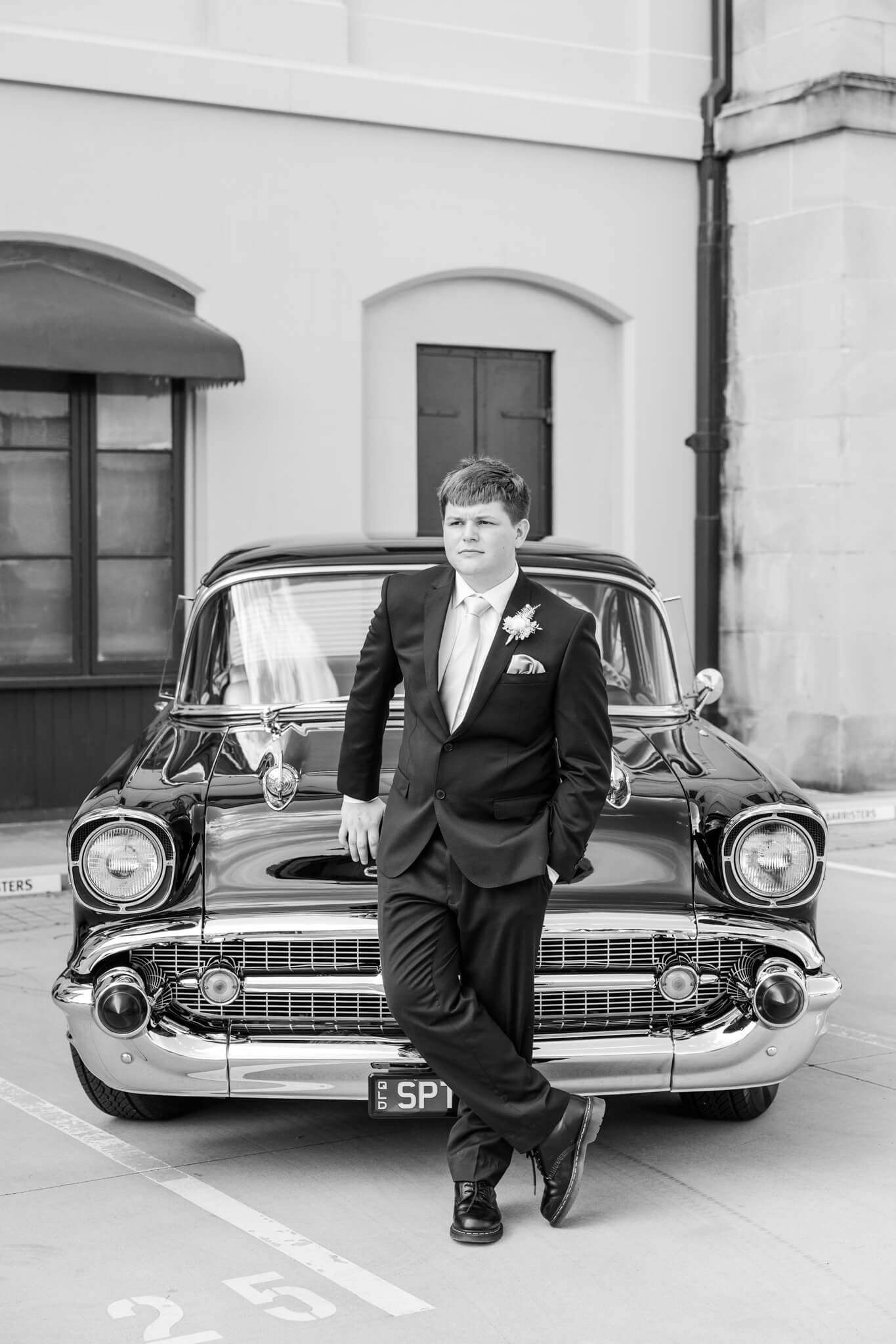 High school senior poses for his formal photos. Black and white image by Julie-Anne Photography.