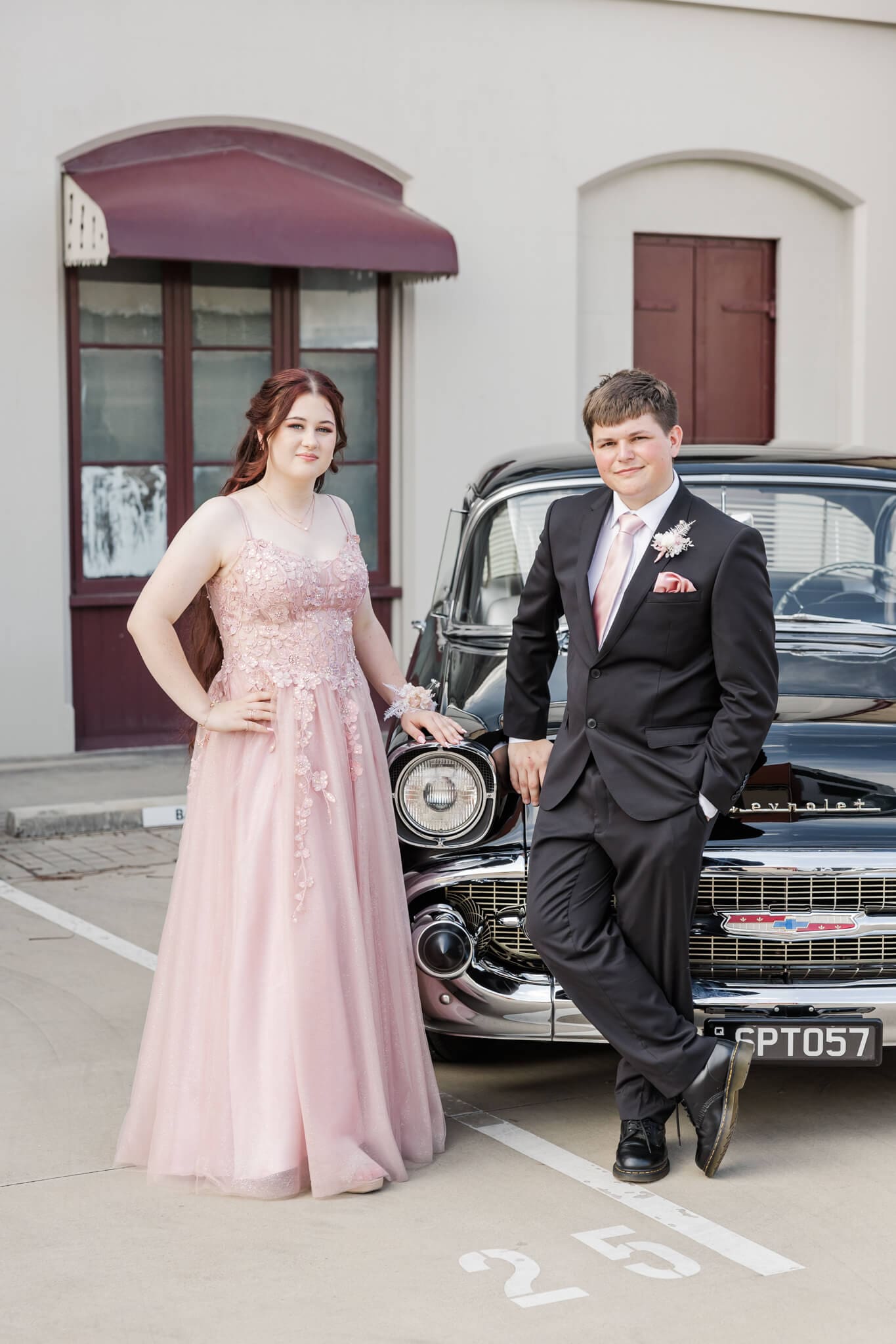 Formal graduates and their car hire in Rockhampton, posing for their formal photos.