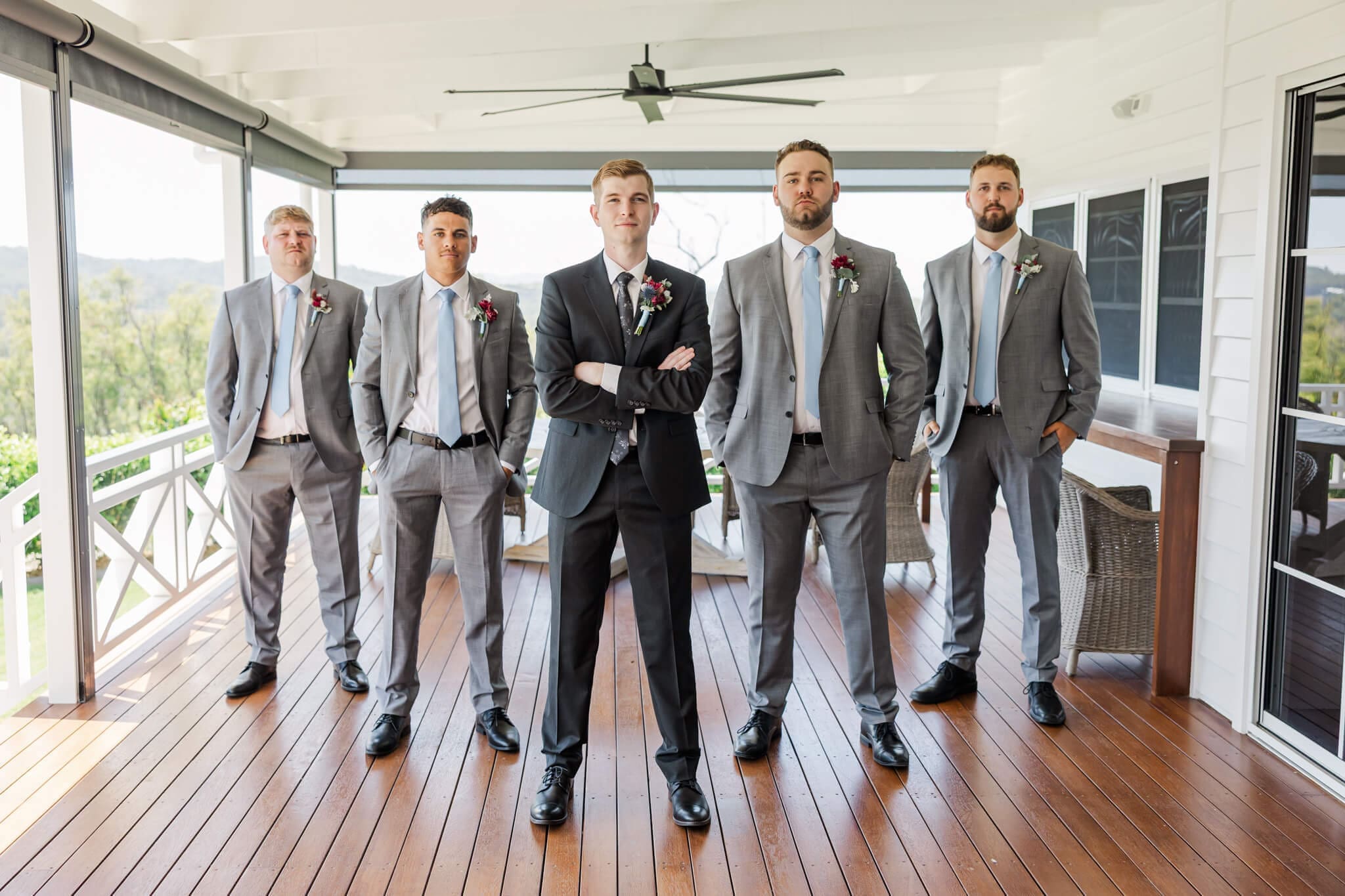 A groom and his groomsmen stand posing for their photos while dressed in their suits from Rockhampton.
