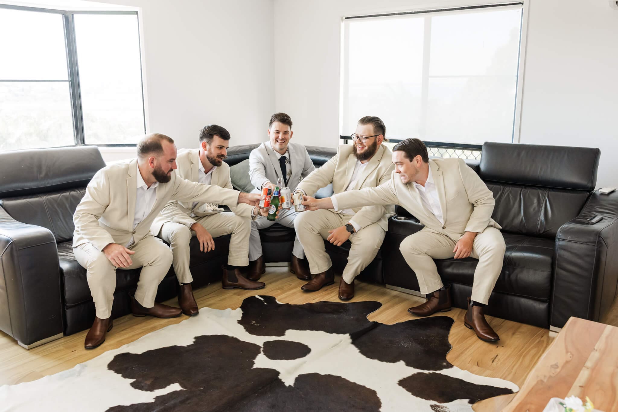The groom and his groomsmen share a drink, all dressed ready in their Rockhampton suits.