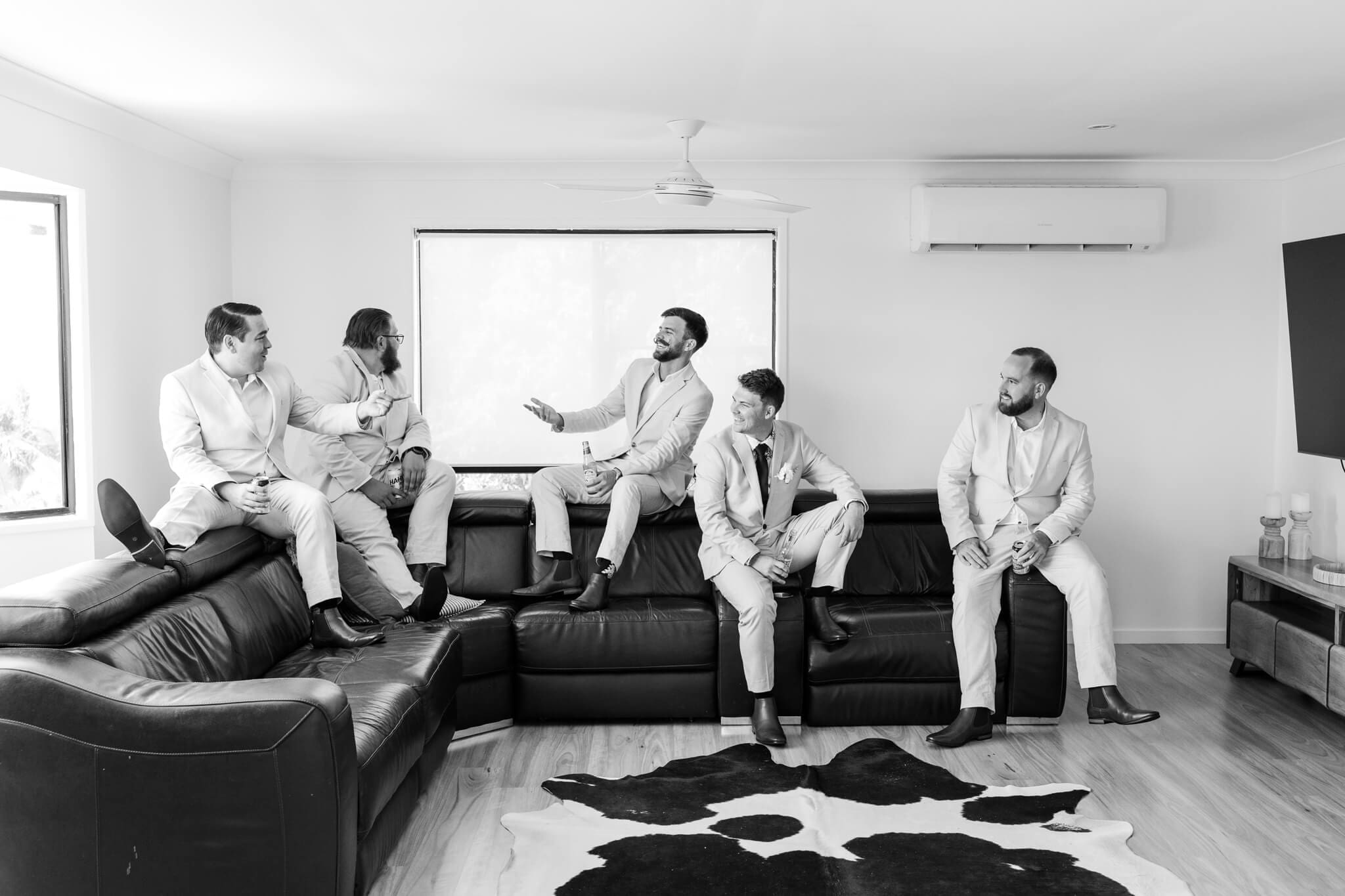 The groom and his groomsmen share a drink, all dressed ready in their Rockhampton suits.
