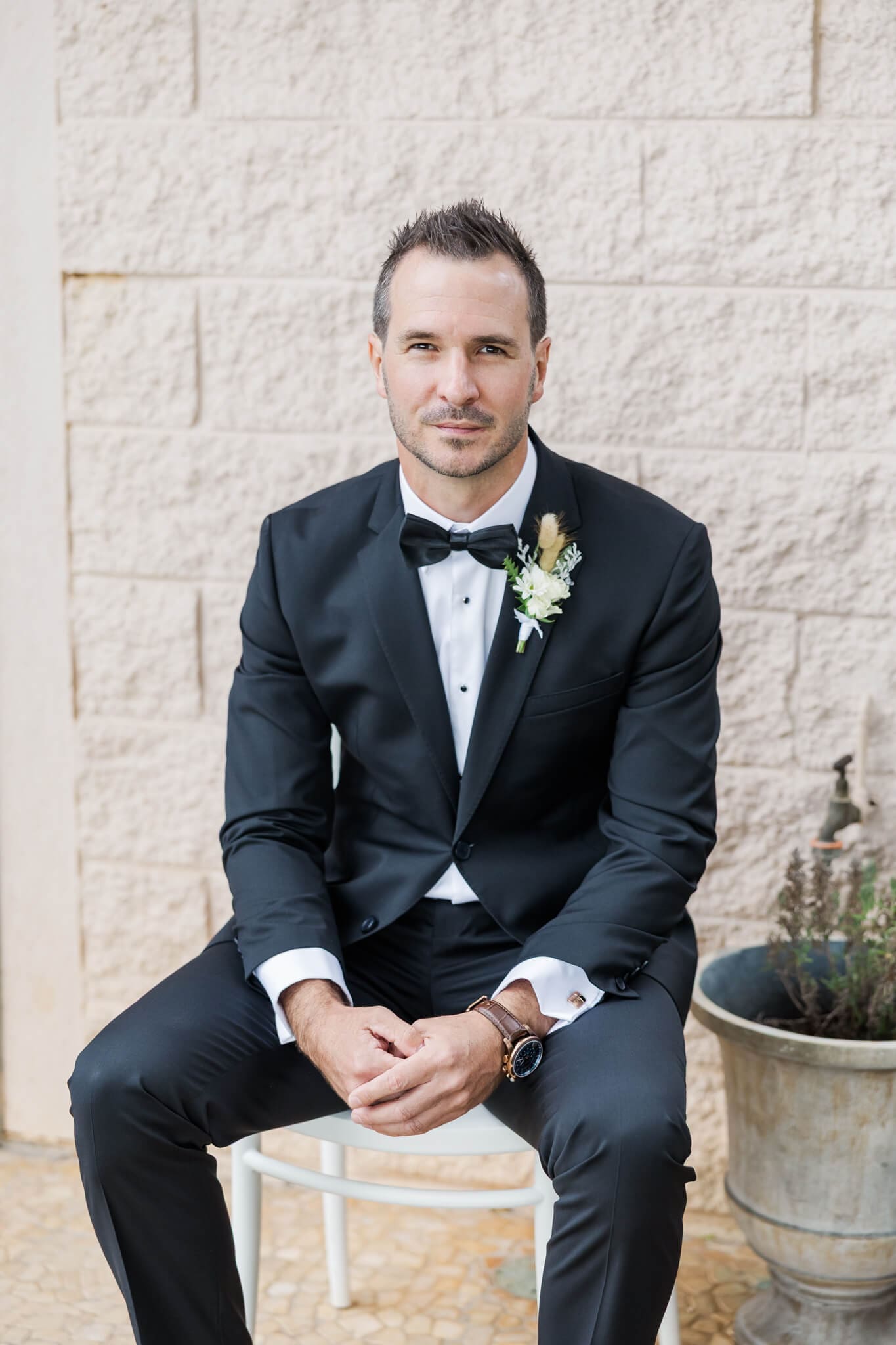 Groom seated, posing in his Rockhampton suit, on his wedding day.