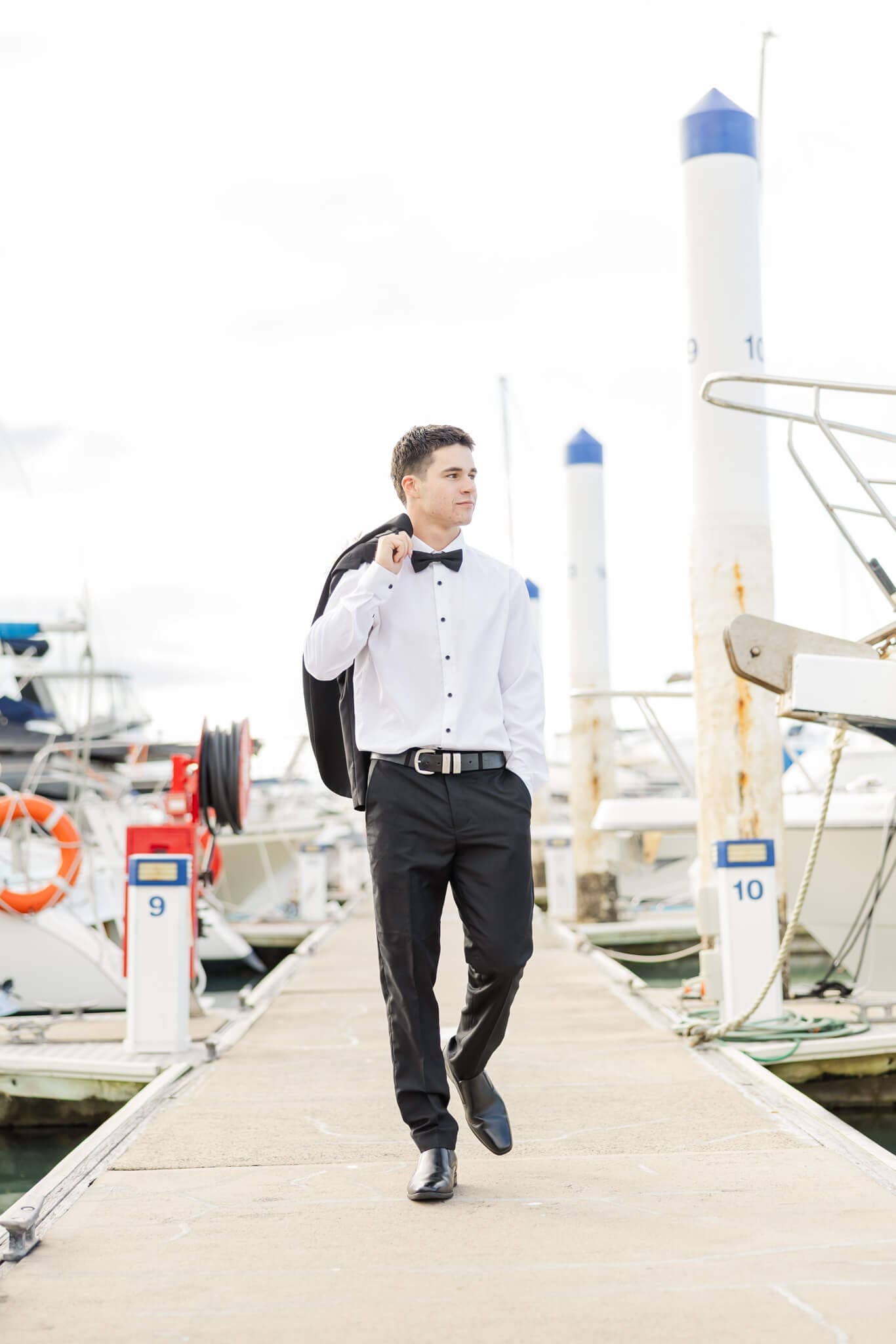 High school graduate walking towards camera wearing an outfit from Stewart's, a store that sells suits in Rockhampton.