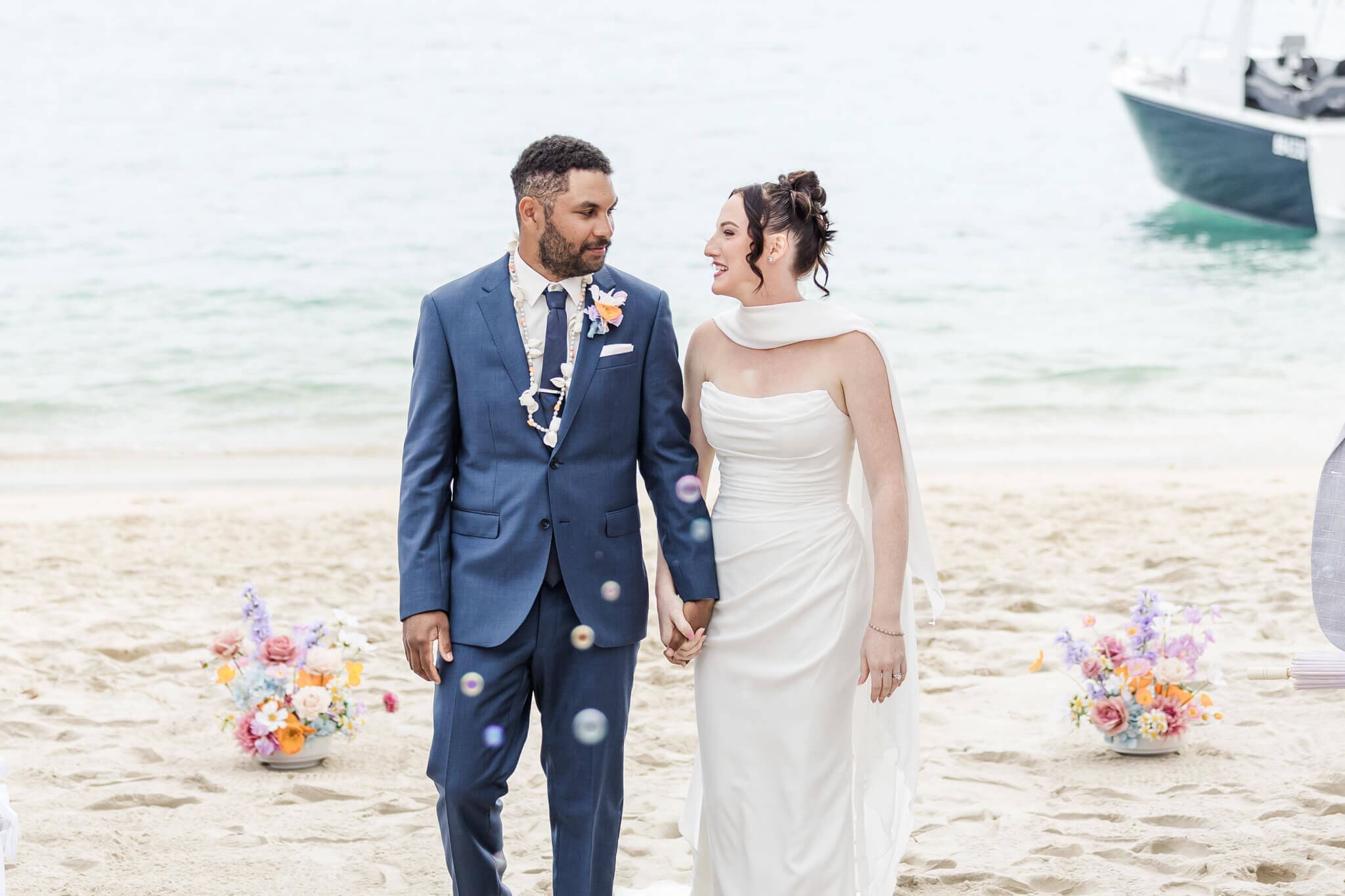 Bride and groom share a glance as they walk down the aisle after their wedding ceremony. Groom dressed in a Rockhampton suit. Photographed by Julie-Anne Photography.