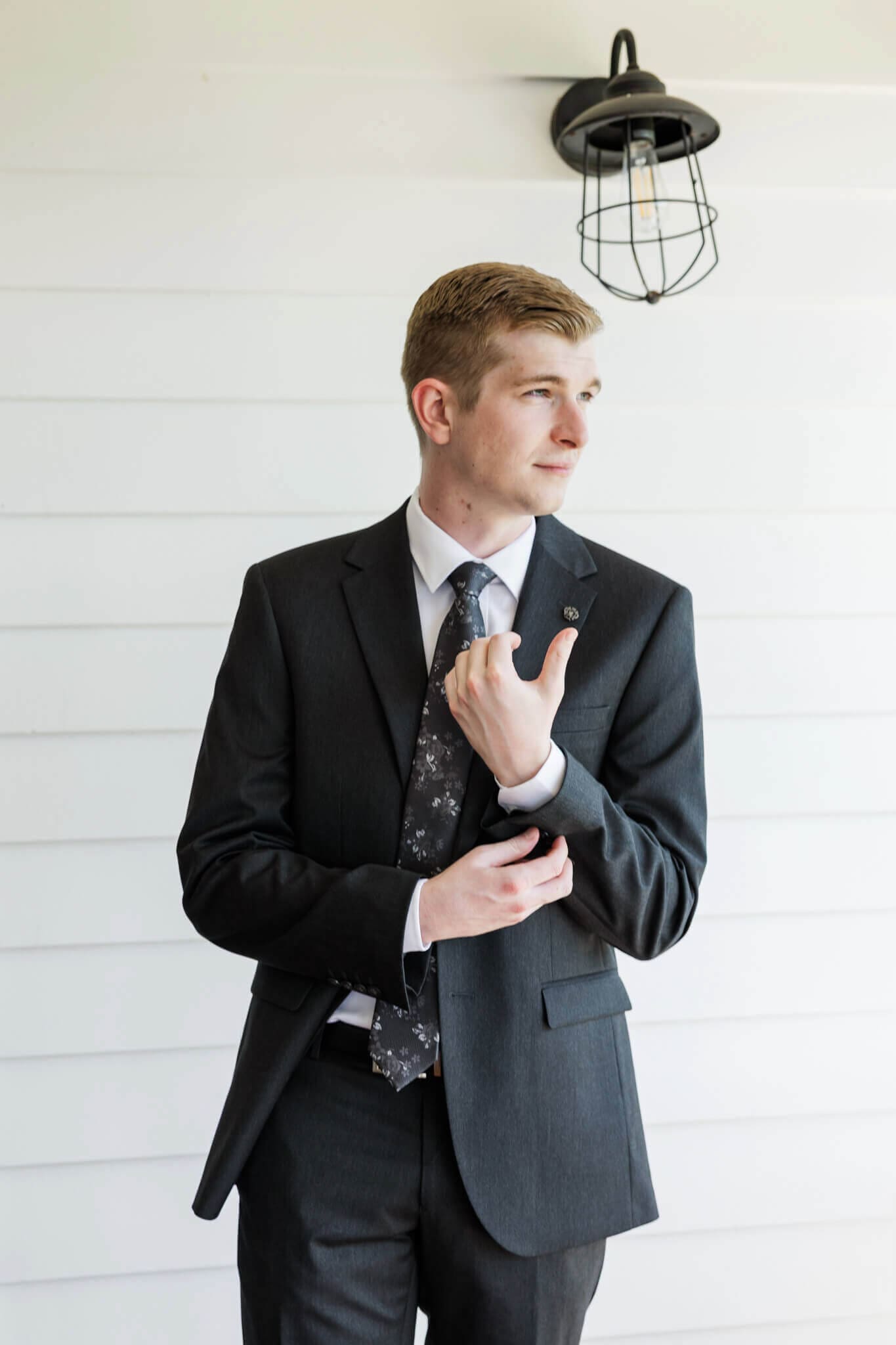 Groom glances out to the distance while getting dressed into his suit from Rockhampton.
