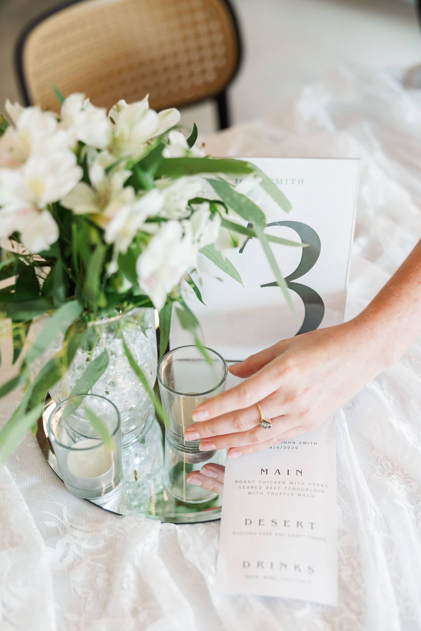 Detail shot of a hand adjusting details on a styled table setting