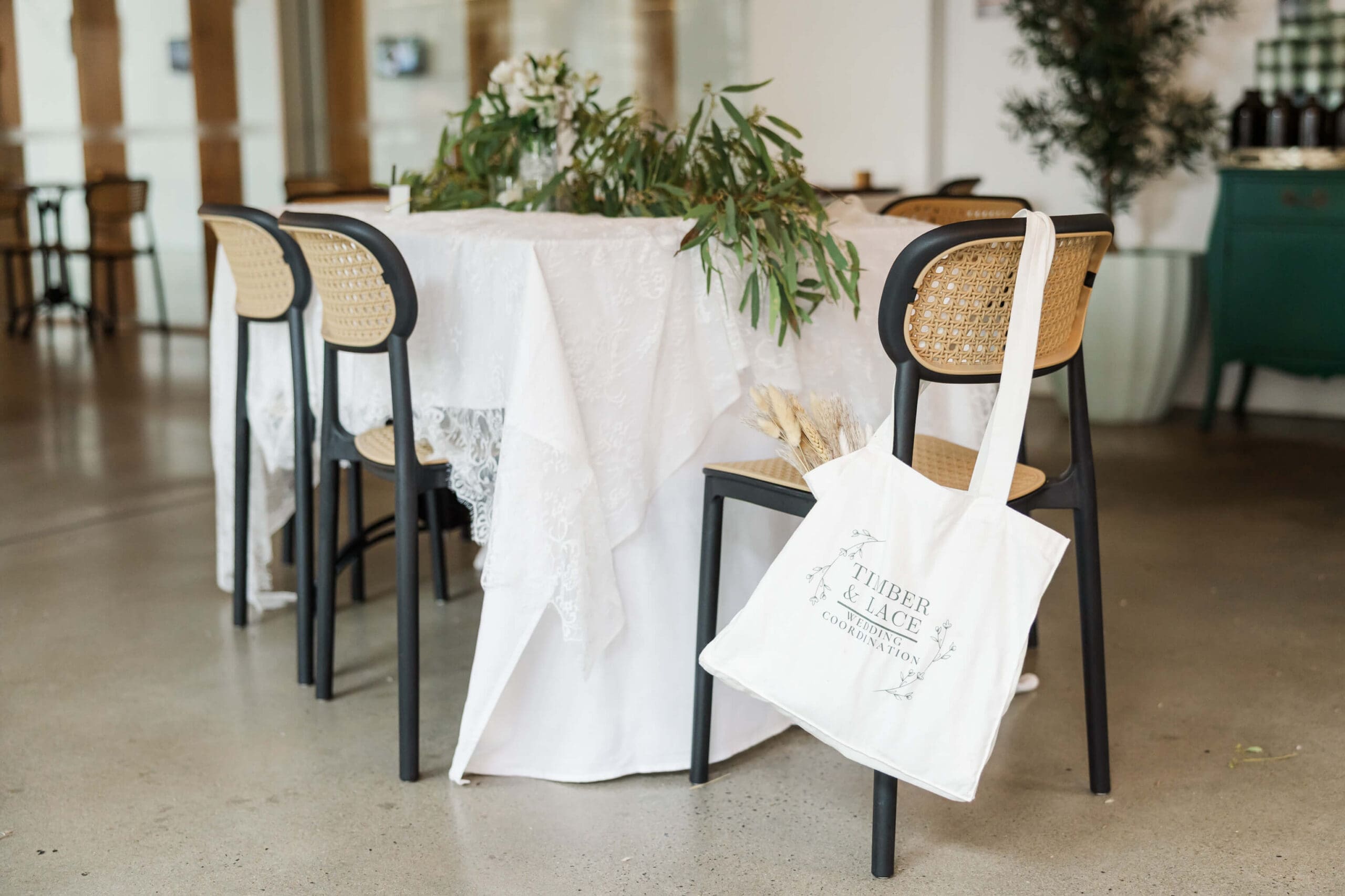 A styled table by Timber and Lace Coordination, a Rockhampton wedding planner featuring a bag with planner's branding on it.