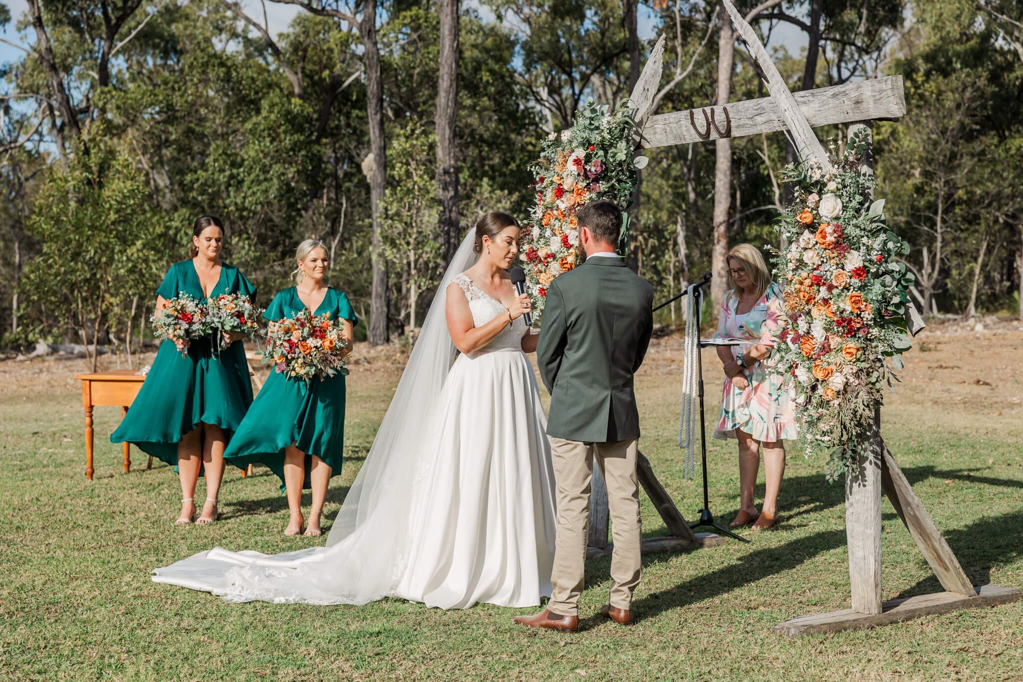 Bride and groom exchange wedding vows in the warm sunshine at a wedding venue near Yeppoon.