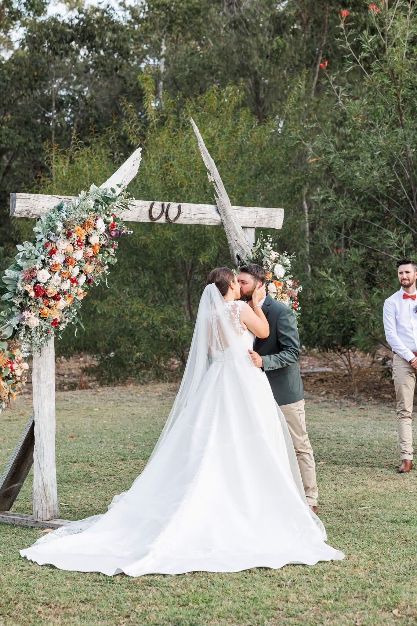 Bride and groom kiss at the ceremony site at The Barn at the Mountain.