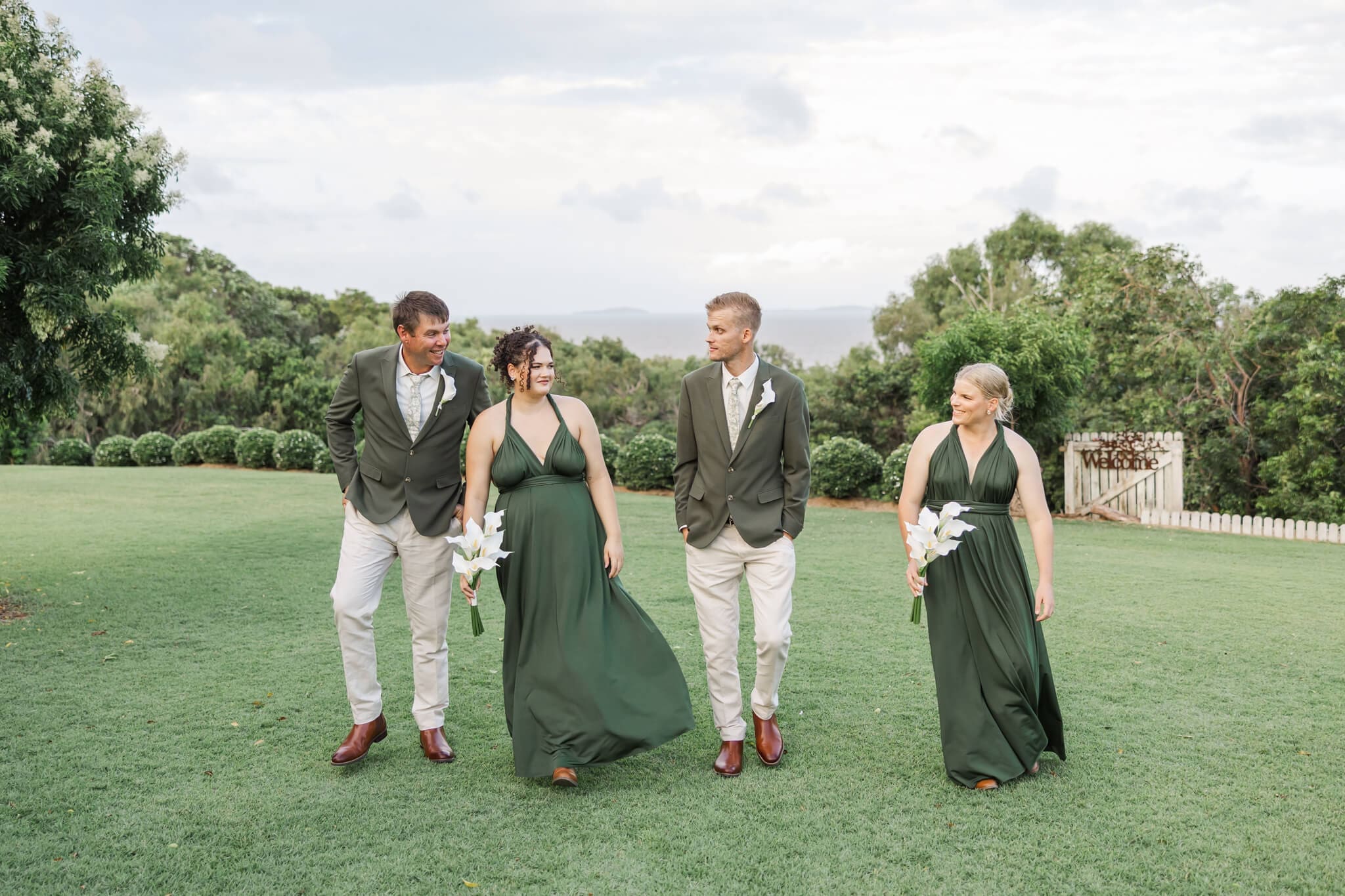 Bridesmaids and groomsmen walk and chat at The Haven Yeppoon, a wedding venue near Emu Park.