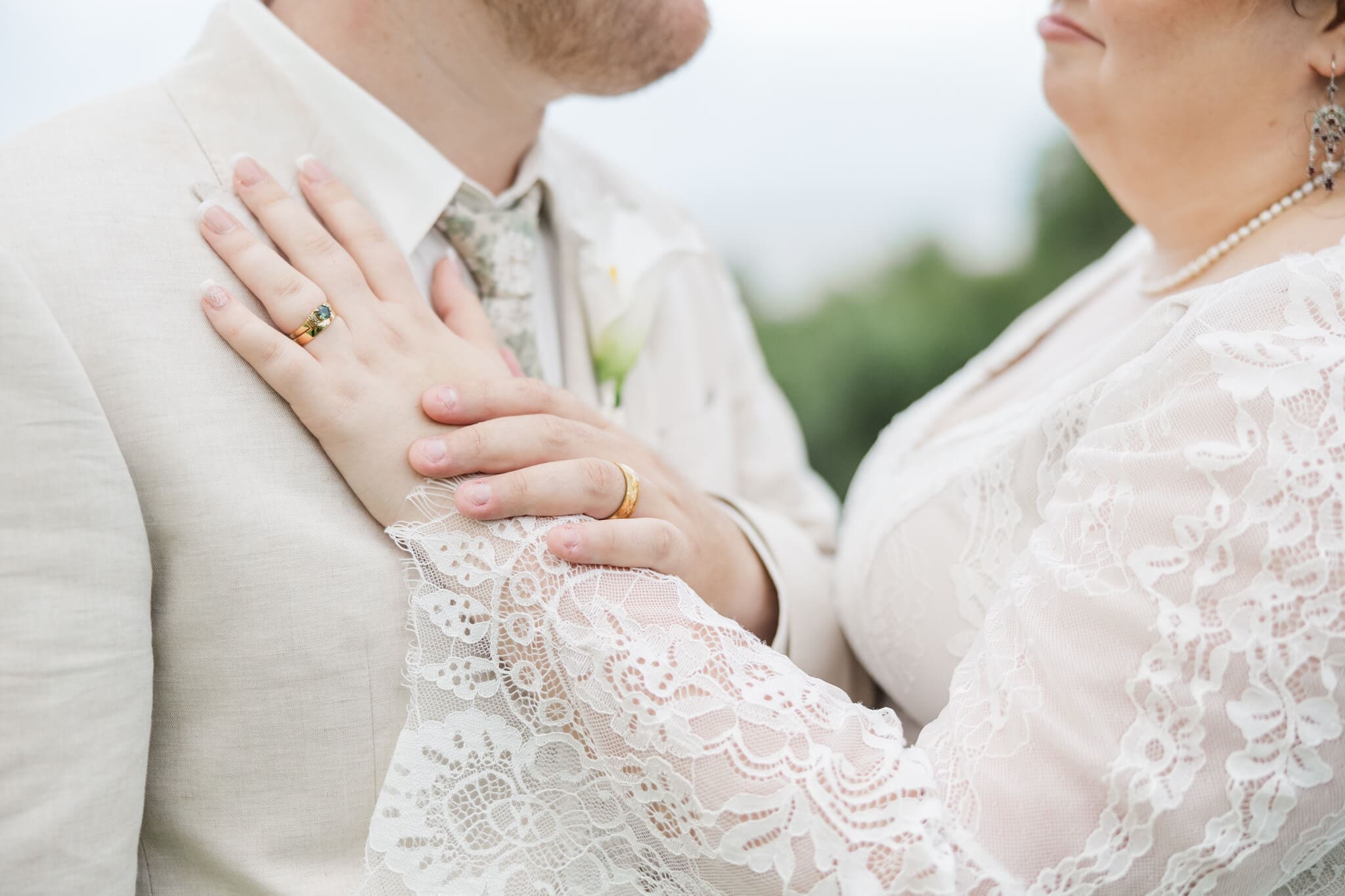 Detail of the bride and grooms hands showing wedding rings off.