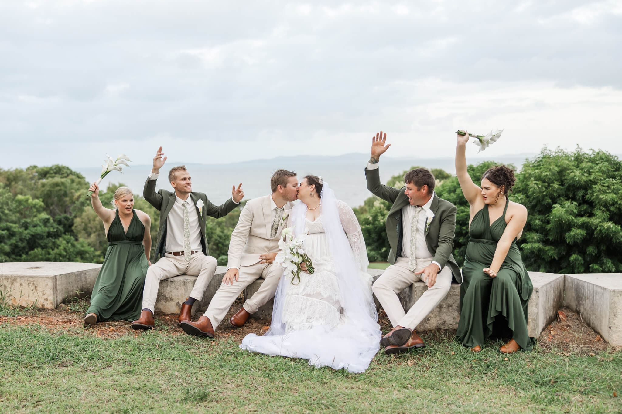 Bridal party cheer as the bride and groom kiss at The Haven Yeppoon, a wedding venue near Emu Park.